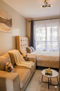 ein Wohnzimmer mit zwei Betten und einer Couch in der Unterkunft Navira Studio with Pool in Nairobi