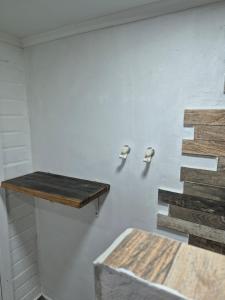 a white wall with a wooden shelf and stairs at Departamentos H&G in Punta Arenas +11 photos