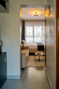 ein Schlafzimmer mit einem Bett, einer Couch und einem Tisch in der Unterkunft Navira Studio with Pool in Nairobi