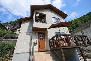 een huis met een bruine deur en een paraplu bij BLUEBAY TERRACE okutama in Okutama