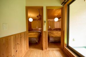 een slaapkamer met 2 bedden en een spiegel in een kamer bij BLUEBAY TERRACE okutama in Okutama