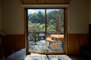 een glazen schuifdeur naar een patio met een tafel bij BLUEBAY TERRACE okutama in Okutama