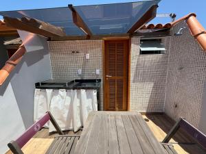 a patio with a wooden deck with a wooden door at Triplex Luxo 2 Qtos c Churrasqueira na Rua das Pedras in Búzios