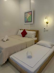 twee bedden naast elkaar in een kamer bij Ivorys Guesthouse in Panglao