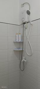 een douche in een badkamer met een douchekop bij Ivorys Guesthouse in Panglao