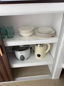 a cabinet filled with dishes and bowls and plates at Ivorys Guesthouse in Panglao