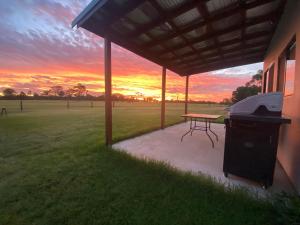a picnic table under a pavilion with a sunset in the background at Hanger Ridge Cabin in Goodger