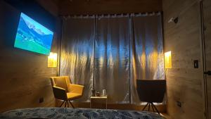 a bedroom with a television and a yellow chair at Boheme Cabin in Medellín +5 photos