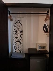 een kamer met een magnetron en een raam met een gordijn bij Hotel Boutique Patio Corao in Cartagena