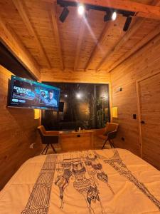 a bedroom with a bed with a flat screen tv at Boheme Cabin in Medellín