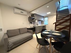 a living room with a couch and a table at Triplex Luxo 2 Qtos c Churrasqueira na Rua das Pedras in Búzios