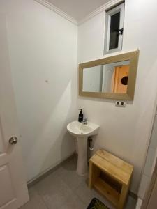 een witte badkamer met een wastafel en een spiegel bij Cactu in Viña del Mar