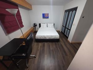 a bedroom with a bed and a desk and a bed sidx sidx sidx at Bujaks in Inuvik +1 photo