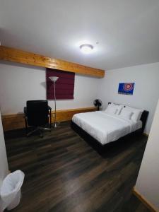 een slaapkamer met een bed, een bureau en een stoel bij Bujaks in Inuvik