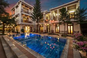 een huis met een zwembad ervoor bij Paradise Boutique Hoi An in Hội An