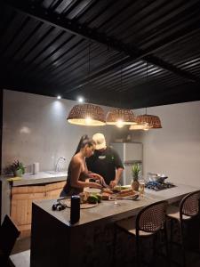 un uomo e una donna che preparano il cibo in una cucina di Villa Bonaire - tobia a Tobia