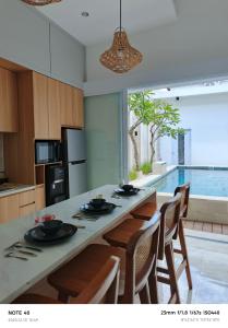 een keuken met een groot eiland met stoelen en een tafel bij Casa Dwi Harmoni Sanur in Pesanggaran