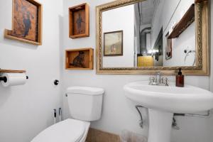 a bathroom with a sink and a toilet and a mirror at St. Vincent Lofts in Los Angeles
