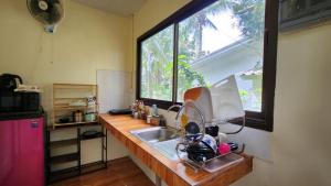 a kitchen counter with a sink and a window at Casa Srithanu in Koh Phangan