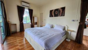 a bedroom with a large bed with white sheets at Casa Srithanu in Koh Phangan