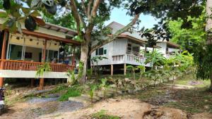 a house with a tree in front of it at Casa Srithanu in Koh Phangan