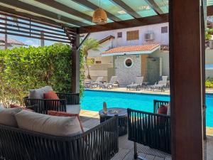 a patio with chairs and a swimming pool at Moreno Guest House com Piscina, churrasqueira Praia de Itaguaré e Riviera in Bertioga