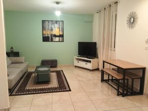 a living room with a couch and a television at Aya in Pompey