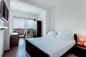 a bedroom with a bed and a desk and a window at Hotel Stella del Benaco in Manerba del Garda