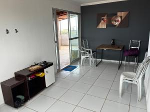 ein Wohnzimmer mit Tisch und Stühlen in der Unterkunft Apartamento Duplex em Jacumã in Conde