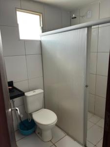 ein kleines Badezimmer mit Toilette und Fenster in der Unterkunft Apartamento Duplex em Jacumã in Conde