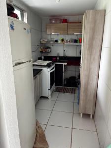eine Küche mit einem weißen Kühlschrank und einem Herd in der Unterkunft Apartamento Duplex em Jacumã in Conde + 7 Fotos