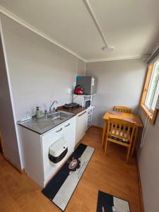 a small kitchen with a sink and a table at Cabaña full A1 in Punta Arenas