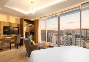 een hotelkamer met een bed en een groot raam bij Panorama Sky Beach Recidences in Nha Trang