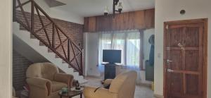a living room with a staircase and a television at Duplex Playa in Santa Clara del Mar
