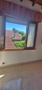a room with a large window with a view of a house at Duplex Playa in Santa Clara del Mar
