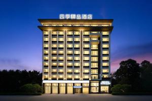万象四季Four Seasons Hotel的一座有灯的旅馆大楼,上面有标志