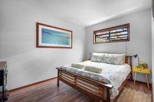 a bedroom with a bed and a picture on the wall at Hyams Reach Retreat in Erowal Bay