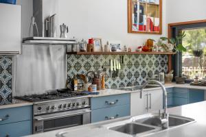 a kitchen with blue cabinets and a stove at Hyams Reach Retreat in Erowal Bay +6 photos