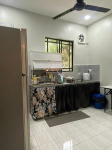 una cucina con bancone al centro di una stanza di D'Kuning Homestay a Gua Sai