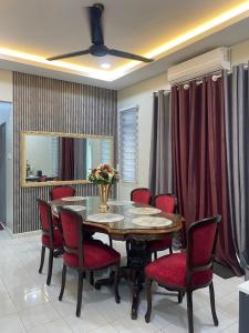 una sala da pranzo con un tavolo e sedie rosse di D'Kuning Homestay a Gua Sai