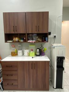 una cucina con mobili in legno e un frigorifero bianco di D'Kuning Homestay a Gua Sai