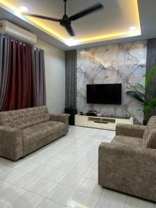 un soggiorno con due divani e una TV a schermo piatto di D'Kuning Homestay a Gua Sai