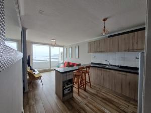a kitchen with wooden cabinets and a counter top at Departamento full equipado in Coquimbo