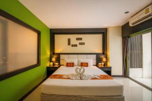 a bedroom with a large bed with green walls at The Star House in Patong Beach