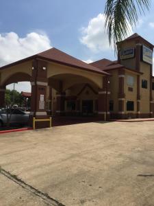 a building with a parking lot in front of it at Scottish Inn & Suites Hobby Airport in Houston