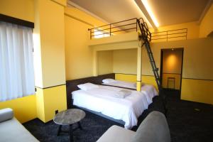 two beds in a room with a bunk bed at TAP Inn MIURA in Miura