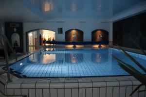 a large swimming pool with blue tiles on the floor at Fewo-Seestern in Friedrichskoog +14 photos