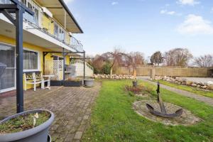 een achtertuin van een huis met een hek bij Fewo-Seetank in Friedrichskoog