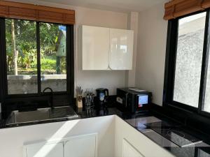 a kitchen with a sink and a microwave at Lucky home in the heart of thongsala in Thong Sala +17 photos