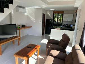 a living room with a couch and a tv and a table at Lucky home in the heart of thongsala in Thong Sala